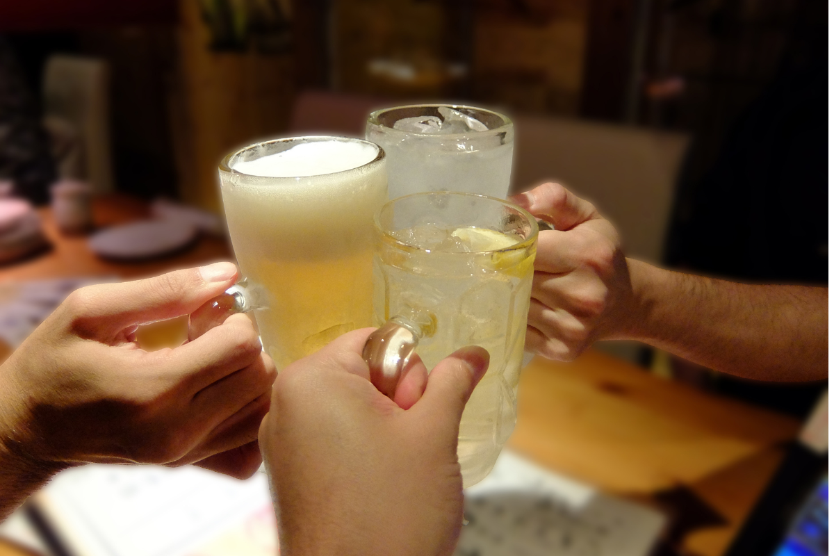 Moment de kanpai avec plusieurs verres de boissons japonaises fraîches inspirées des izakaya.